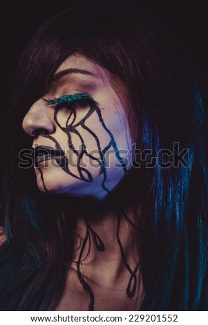 concept, crying woman with tears and makeup dark light