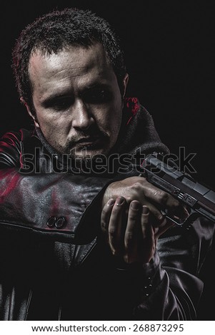 thief with gun in hand. man in leather jacket
