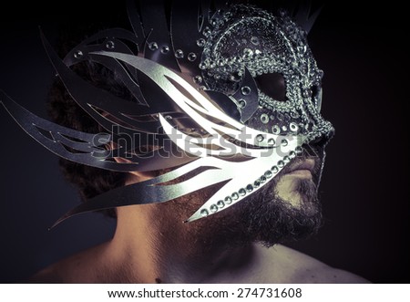 Shiny, bearded man with silver mask Venetian style. Mystery and renaissance