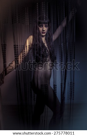 naked girl behind curtains of black threads