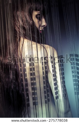 naked girl behind curtains of black threads