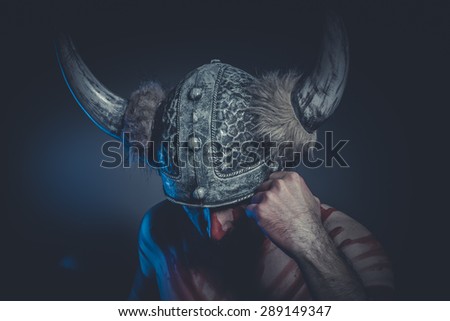Viking warrior with a horned helmet and war paint on his face