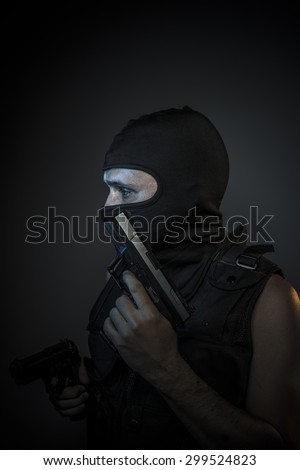 Man wearing balaclavas and bulletproof vest with firearms