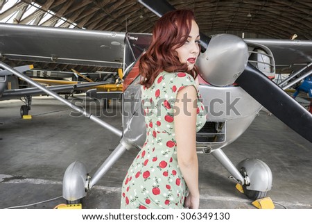Aircraft, pinup dressed in era of the Second World War, beauty redheaded woman