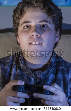 boy with joystick playing computer game at home.