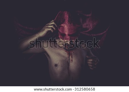 naked man on large red cloth over his eyes