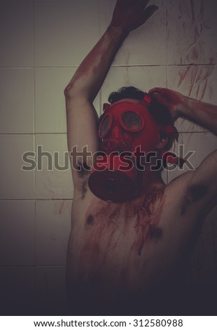 Lonely, desperate man, anguish and suffering with red gas mask