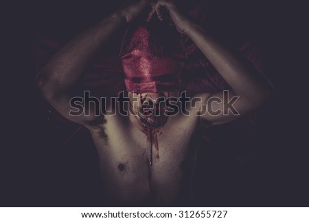 Dead, naked man on large red cloth over his eyes