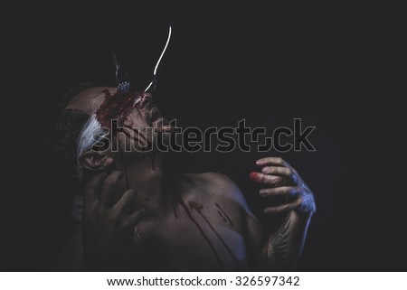 naked man with blindfold soaked in blood