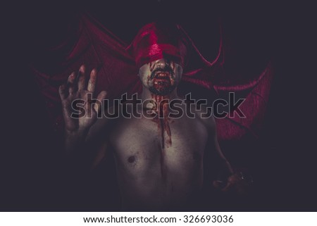 Halloween, naked man on large red cloth over his eyes