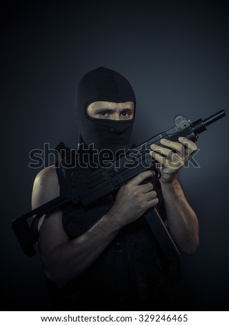 Weapon, terrorist carrying a machine gun and balaclava