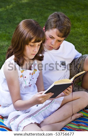 Portrait of cute kids reading books  in natural environment