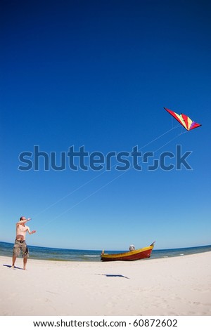 Man with a kit on a beach. Kiting on a low wind.