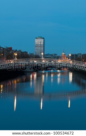 stunning nightscene with Ha\'penny bridge and Liffey river, the Custom House landmark at the background (picture taken after sunset)