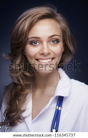 Young doctor woman with stethoscope on dark blue background
