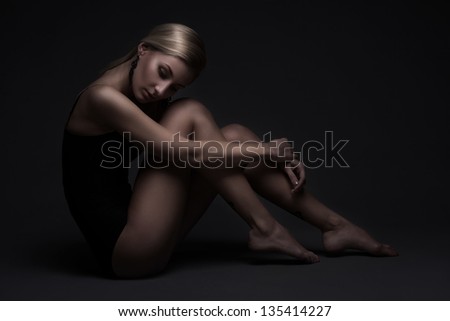 Sexy woman in black swimsuit isolated on dark background