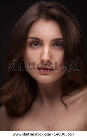 Young woman with beautiful healthy face isolated on black background
