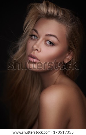 Portrait of a stunning blonde beauty on dark background
