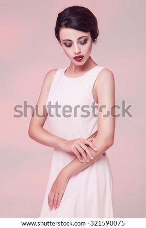 portrait of beauty woman in white dress isolated over light pink studio background