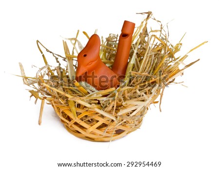 Clay whistle bird in a straw nest
