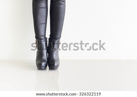 Woman wearing black leather pants and high heel shoes