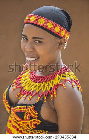 South Africa, Gauteng, Lesedi Village (unique center of African culture) - 04 July, 2015 . Smiling young black beautiful Zulu woman in traditional handmade colorful scarlet yellow beads clothes.