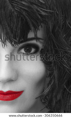 Close-up portrait of mysterious young beautiful woman with black feather headdress. Model fashion shooting. Smoky eyes make-up. Red sensual lips. Femme fatale. Retro style. Vintage. Cabaret girl.