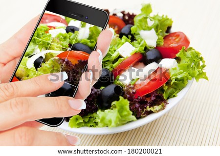 closeup of hand making photo of salad by cellphone