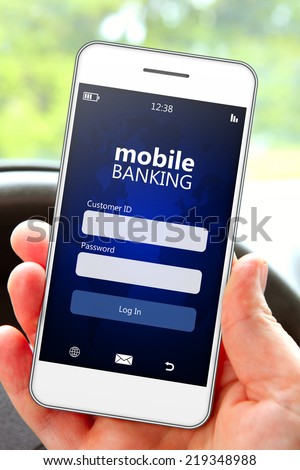hand holding mobile phone with banking log in page in the car