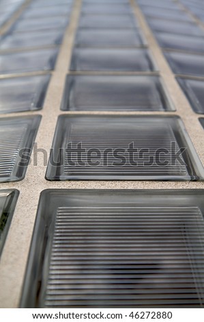 Lots of glass blocks or bricks on a curved wall ascending into diminishing soft focus