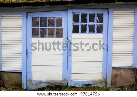 Couple of old weathered Blue Bordered  Garage Doors