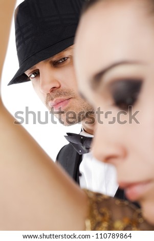 Young handsome man with hat looking at camera behind woman silhouette