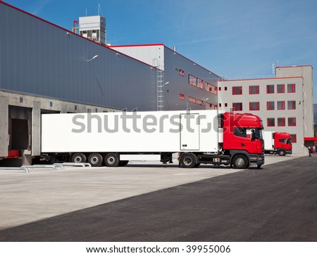 cargo trucks at an entrance of a warehouse