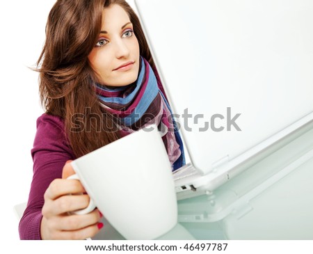 beautiful young female sitting behind laptop with a cup