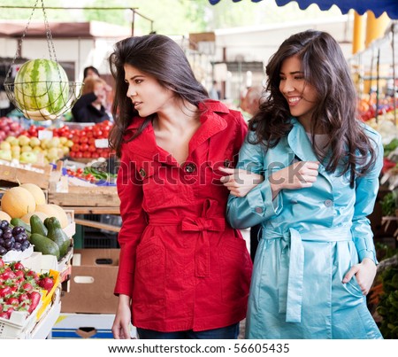 Two beautiful young twins walking together a farmers market