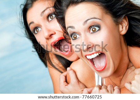 Close-up of two females faces screaming with excitement