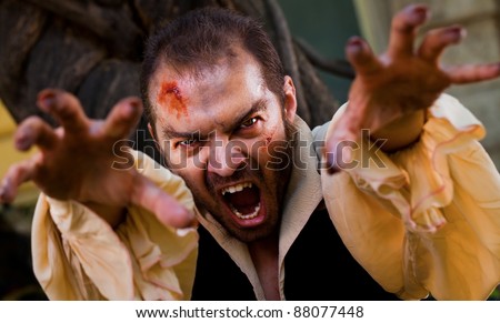 Evil male vampire reaching hands to the camera and roaring