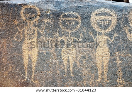 Ancient rock art in Niger depicting three round headed figures