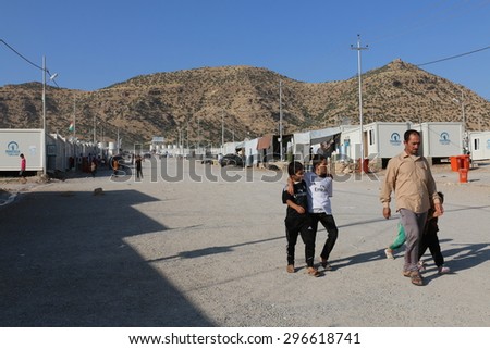 RWANGA REFUGEE CAMP, ZAKHO, KURDISTAN, IRAQ - 2015 JULY 13 - A family walking down the main street in Rwanga (rwanga refugee) camp