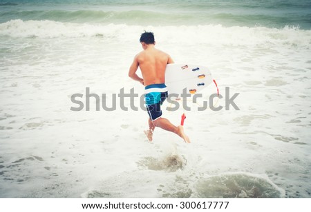 surfers running into the sea with surf boards on patong puket thailand,vintage Instagram retro hipster