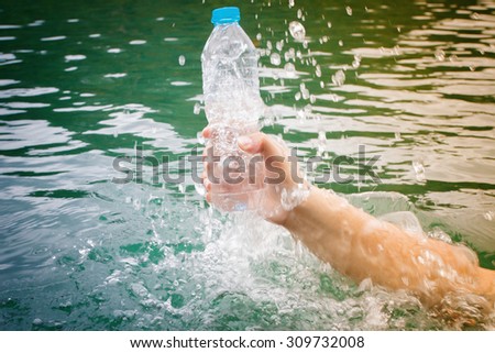 Man holding a bottle of water at lake, health care, healthy