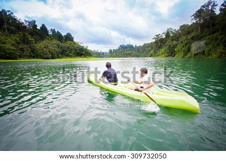 Kayaker so happy extreme sporting a kayak cuts through water with nature background