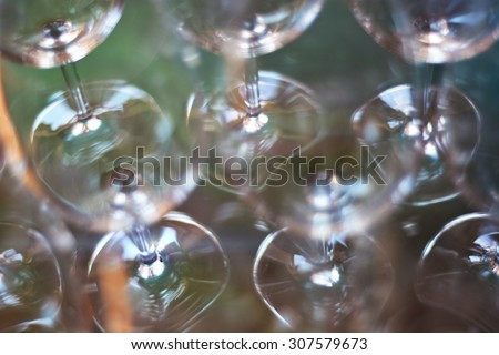 Wine glasses shallow focus blurred foreground defocused background bokeh light optical refraction sun flares.