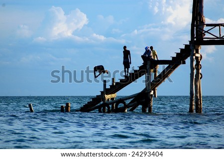 Youth diving from a pier on Prison Island in Indian Ocean