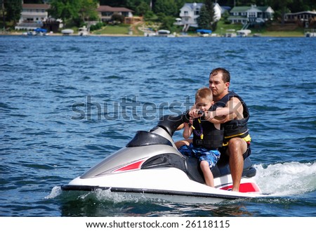 a father and son take a ride on a personal water craft