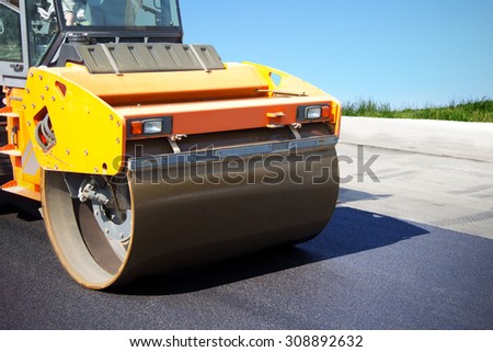 Asphalt roller at work, construction of new roads, repair of pavement, lining country roads, modern construction equipment