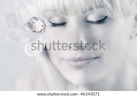 Close-up of fresh and beautiful woman face with flower