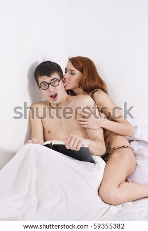 A girl trying to get some attention from her shocked boyfriend, who's busy reading a book.