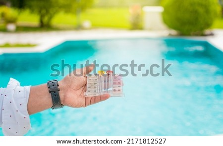 Hand holding Water Test Kit on blurred pool background, Hand holding a pool ph and chlorine tester, Person holding complete water test kit with blurred pool background Photo stock © 