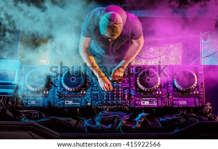 Charismatic disc jockey at the turntable. DJ plays on the best, famous CD players at nightclub during party. EDM, party concept. Сток-фото © 